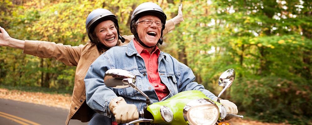 Senior Couple Riding Scooter after Downsizing