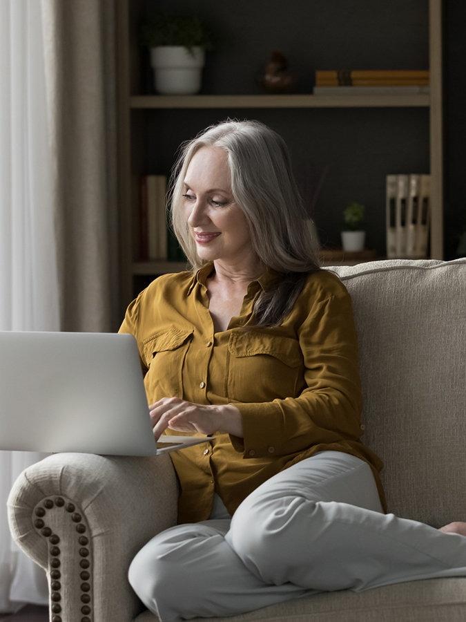Woman on Laptop on Couch at Home